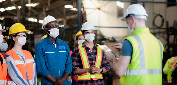 Safety Training taking place in a warehouse with workers facing the instructor